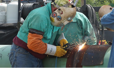 A worker welds a gas pipeline