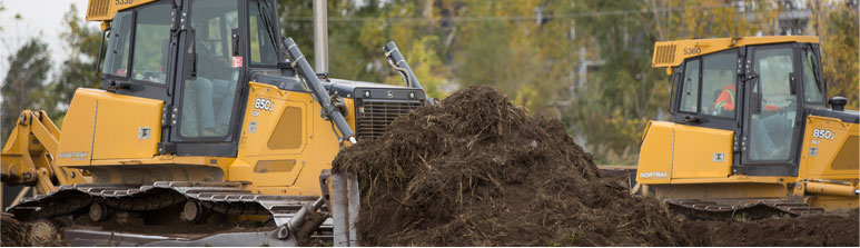 Two bulldozers remove topsoil