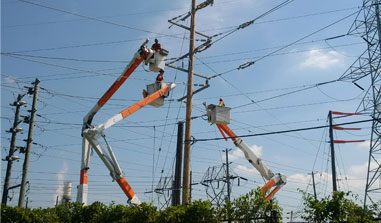 Workers on cherrypickers relocate power lines