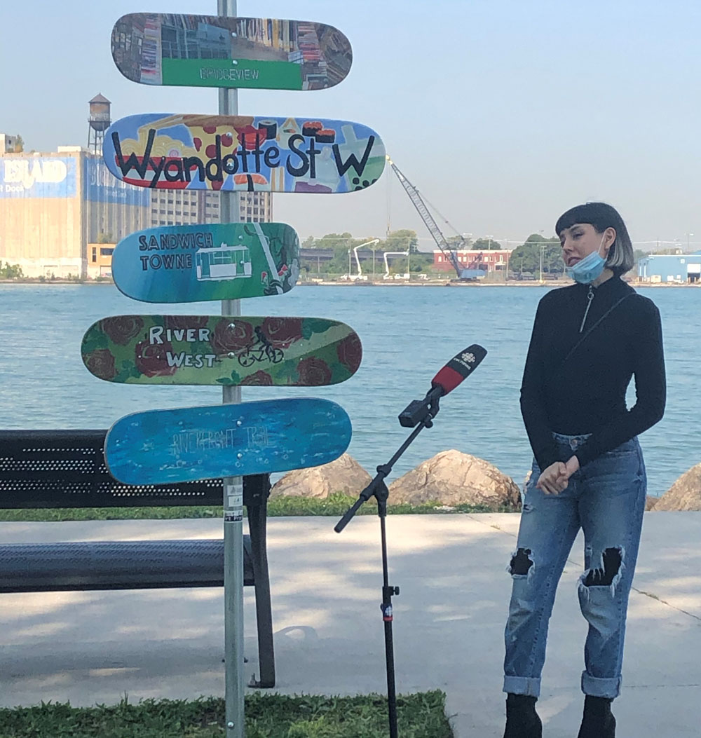 A woman stands next to a skateboard sculpture