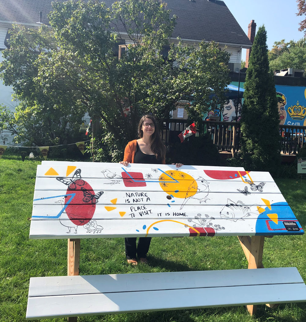 Kristina Bradt stands behind her painted picnic table