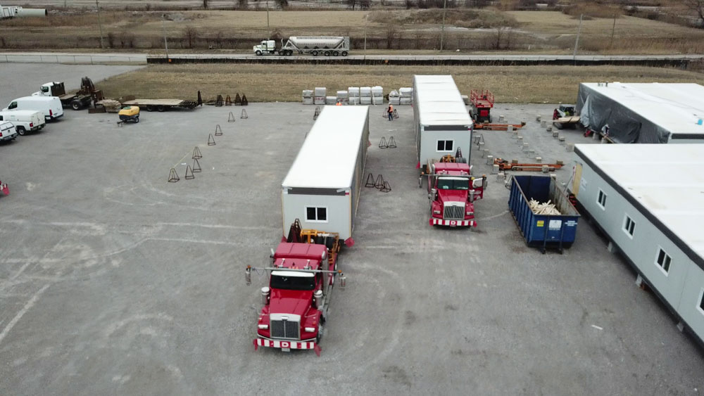 Deux camions rouges avec remorques au bureau de construction de Bridging North America.