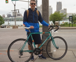 Bobby Butler standing in front of a green bicycle